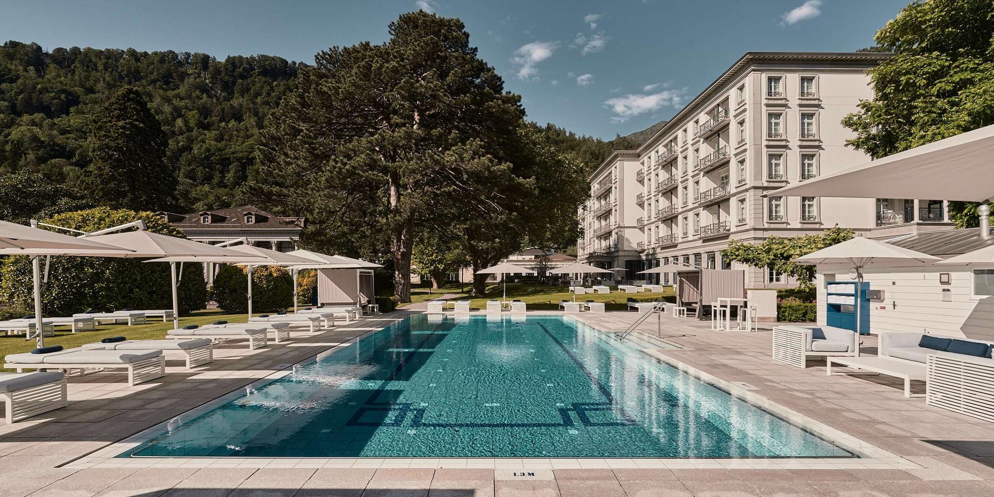 A picture of an outside pool at Grand Resort Bad Ragaz in Switzerland featuring a white building. The outdoor pool of Grand Resort Bad Ragaz in Switzerland.