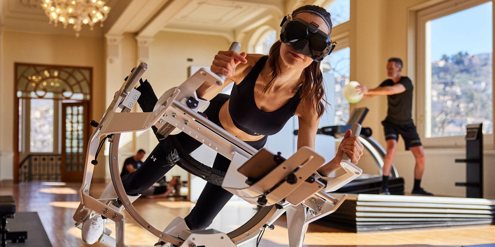 A woman using an ICAROS Pro VR machine at a movement lab at Palazzo Fiuggi in Italy. A person using an ICAROS Prov VR machine at Palazzo Fiuggi in Italy