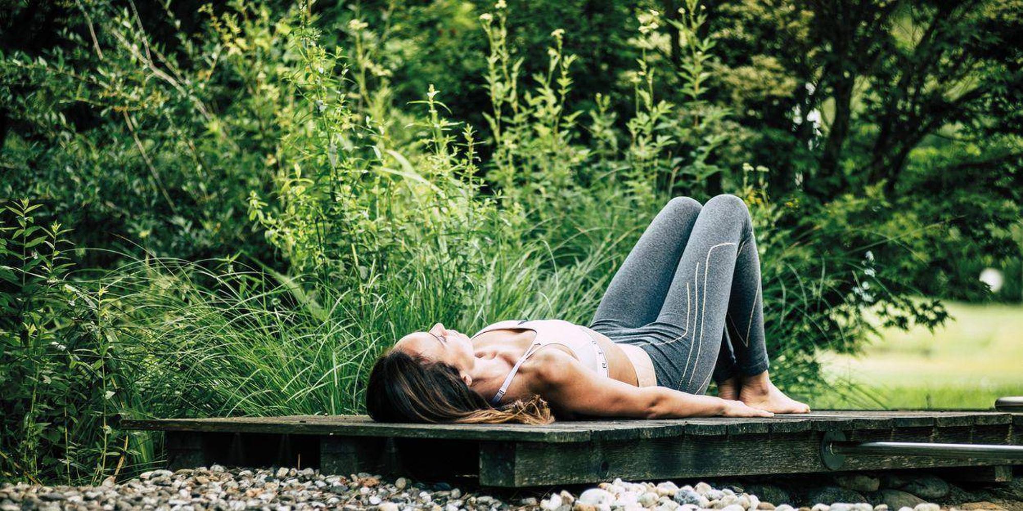 A person engaging in a yoga pose outdoors wearing athletic attire.