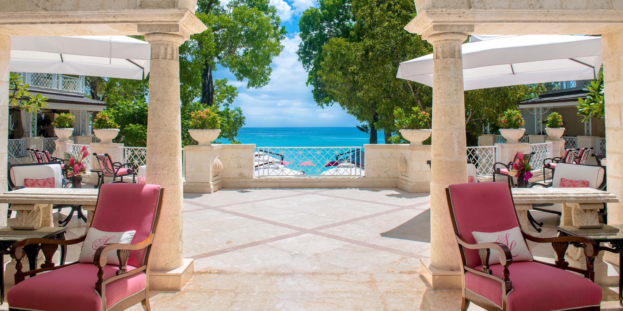 Pink dining chairs and stone pillars overlooking the ocean at the iconic Sandy Hotel in Barbados. Pink dining chairs and stone pillars overlooking the ocean at the iconic Sandy Hotel in Barbados.