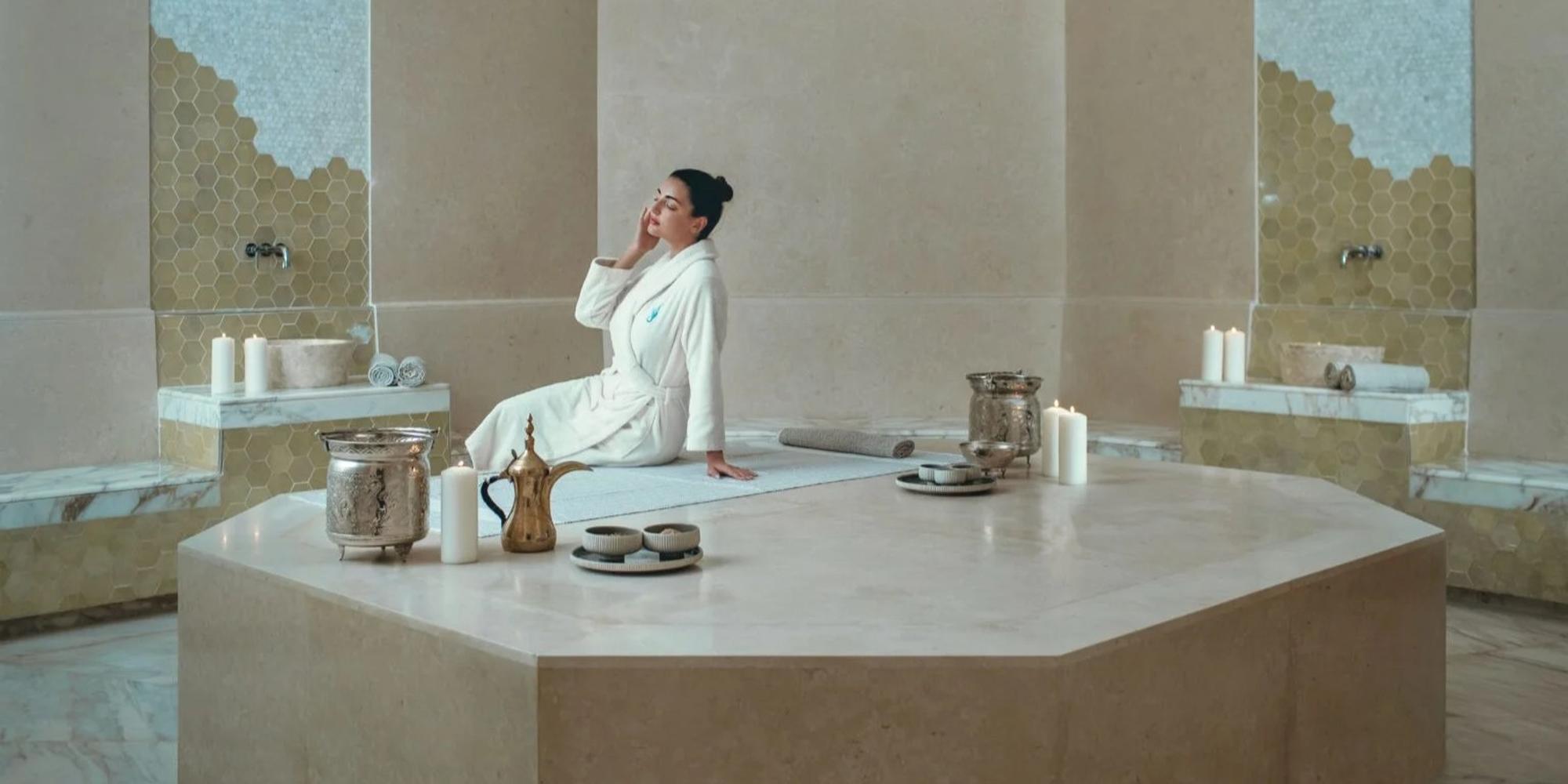 A woman in a white gown in a spa setting at Zulal in Qatar.